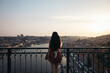 © Pedro Merino/Stocksy - Young woman watching Porto city from the bridge