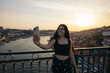 © Pedro Merino/Stocksy - Tourist taking a selfie in the city of Porto
