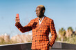 © Ezequiel Giménez/Stocksy - Fashionable black guy taking selfie in city park