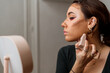 © Felix Chacon/Stocksy - Woman applying contour.
