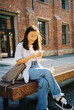 © Oleksii Syrotkin/Stocksy - Woman messaging remotely on street