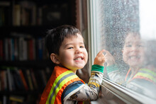 Happy Kid Indoors On Rainy Day