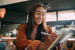 © Jovo Jovanovic/Stocksy - Young Asian woman taking notes in notebook