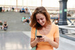 © Ivan Gener/Stocksy - Woman reading a text and smiling during her commute