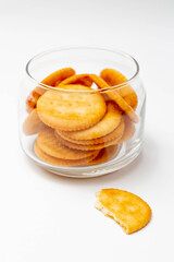 Wall Mural - Snack concept, Salty crackers or biscuits in a glass jar with cracker scrap on white background