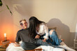 © ByLorena/Stocksy - Happy couple having fun in bedroom at dawn