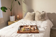 © ByLorena/Stocksy - Queen bed with breakfast tray at dawn