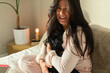 © ByLorena/Stocksy - Brunette woman holding cute black dog in bedroom