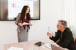 © Ivan Gener/Stocksy - Businesswoman talking with a man during a presentation