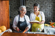 © Marcos - Hispanic women grandmother and daughter cooking at home kitchen in Mexico Latin America