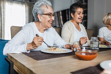 Hispanic Elderly Woman Eating Dinner With Family At Home In Mexico Latin America