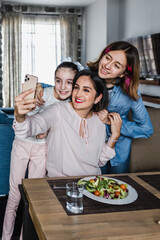 Wall Mural - hispanic women Family Mother and daughters Posing For photo Selfie at dinner time At Home in Latin America