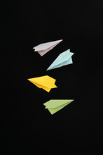 Multi-colored Paper Planes Flying On A Black Background