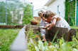 © AD Astra Team/Stocksy - Mom and daughter plant seeds in the garden