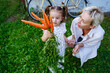 © AD Astra Team/Stocksy - Mom and daughter hold a bunch of carrots near a country house