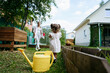 © AD Astra Team/Stocksy - Mom and daughter watering the garden