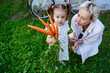 © AD Astra Team/Stocksy - Mom and daughter hold a bunch of carrots near a country house