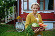 © AD Astra Team/Stocksy - A woman holds a basket of vegetables from her garden