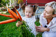 © AD Astra Team/Stocksy - Mom and daughter hold a bunch of carrots near a country house