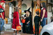 © Sean Locke/Stocksy - Shop Owner Witch Gives Halloween Candy To Kids