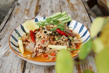 Spicy minced pork salad served with fresh vegetables  Minced pork salad is a popular traditional Thai food of Thailand.  Spicy Minced Pork Salad is also called Larb Moo.