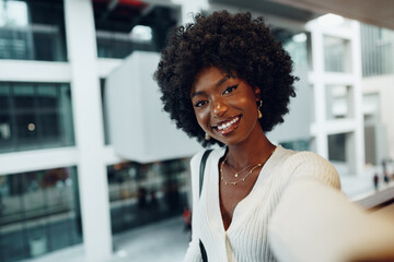 Portrait of young african woman with hairstyle standing at balcony and posing.