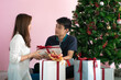 © themorningglory - Man giving  christmas present to his girlfriend and decorate christmas tree celebrate winter new year