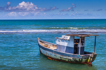 Wall Mural - Porto Seguro Beach at sunset with fishing trawler motorboat in BAHIA, Brazil