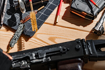 Sticker - Black disassembled shotgun and cleaning tools on wooden table .