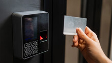 A woman opens the door with a plastic card. Modern keyless entry lock. 