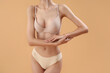© Pixel-Shot - Slim young woman in underwear on beige background