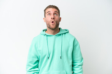 Poster - Young handsome caucasian man isolated on white background looking up and with surprised expression