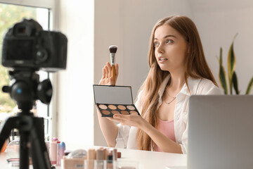 Wall Mural - Female beauty blogger with brush and eyeshadows recording video in dressing room