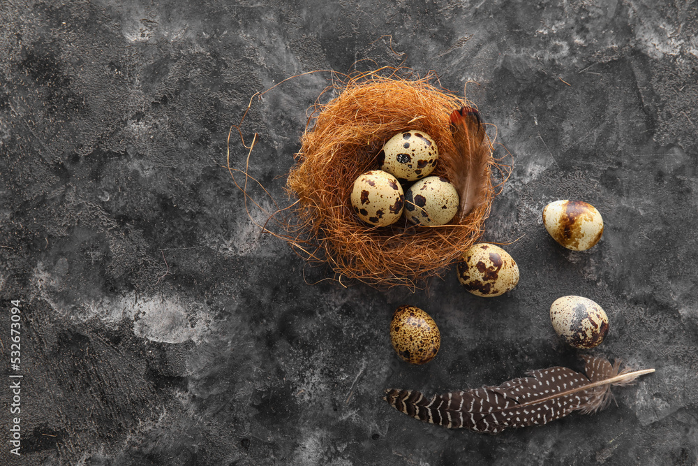 Nest with fresh quail eggs on grunge background