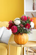 © Pixel-Shot - Pumpkin with beautiful flowers on table in living room, closeup