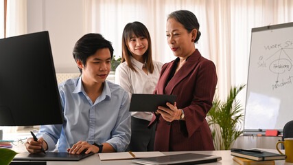 Wall Mural - smiling senior business leader negotiating growth business plan with young employees at meeting