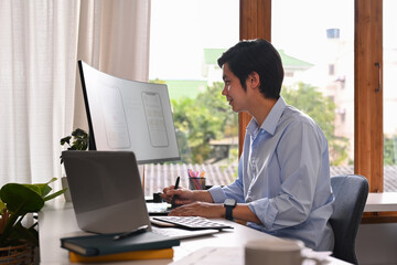 Wall Mural - professional web developer working with prototype wireframe for web mobile phone on computer screen