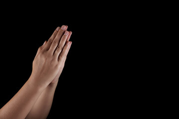 Woman holding hands clasped while praying on black background, closeup. Space for text