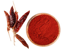 Top view of smoked red paprika in a wooden bowl and a few pepper pods on a white background.