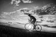 © Solid photos - Young sports man cycling with bicycle on the road in summer in black and white