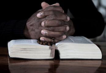 praying to God with the bible and cross on a table at home stock photo