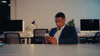 © LIGHTFIELD STUDIOS - African american businessman in suit using cellphone in office at night.