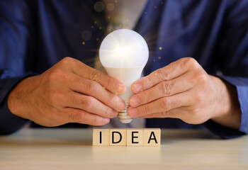 Poster - Concept new idea concept with innovation and inspiration, innovative technology in science and communication concept, hands holding light bulb.