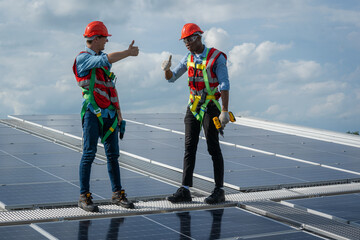 Wall Mural - Technician wearing safety harness belt during installing the solar panels on roof structure of building factory,Economic energy and cost saving concept.