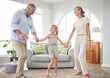© David L/peopleimages.com - Love, retirement and family dancing in home living room together to bond with cute girl child. Happy senior grandmother and grandfather enjoy fun in family home with young grandchild.
