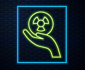 Glowing neon line Radioactive in hand icon isolated on brick wall background. Radioactive toxic symbol. Radiation Hazard sign. Vector