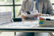 © ArLawKa - Businessman working in finance with pile of unfinished papers on the desk business paper pile