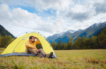 Wall Mural - trip to Caucasus mountains, Arkhyz, Teberdinsky reserve. Man traveler relaxing in mountains in tent camping outdoor Travel adventure lifestyle concept hiking active vacations.