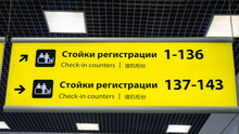 Airport Signboard With Check-in Counter Information Sign At Airport In Russian And English