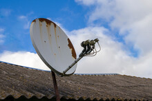 Old Satellite Dish On The Roof. Rusty Satellite Dish On The Roof Of A Rural House. Satellite Television.